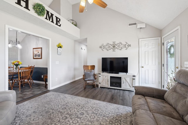 living room featuring visible vents, baseboards, ceiling fan with notable chandelier, wood finished floors, and high vaulted ceiling