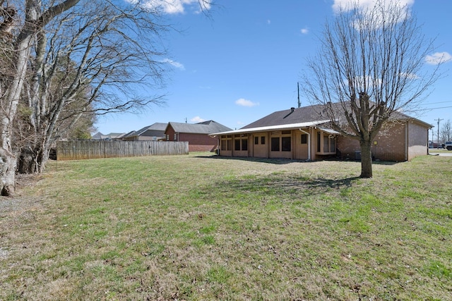 view of yard featuring fence and a sunroom