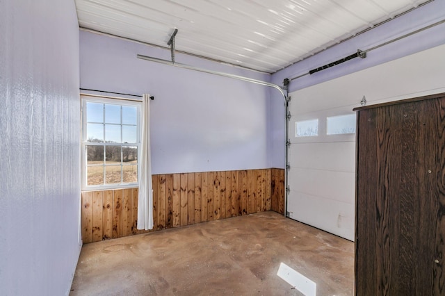 garage with wooden walls and a wainscoted wall