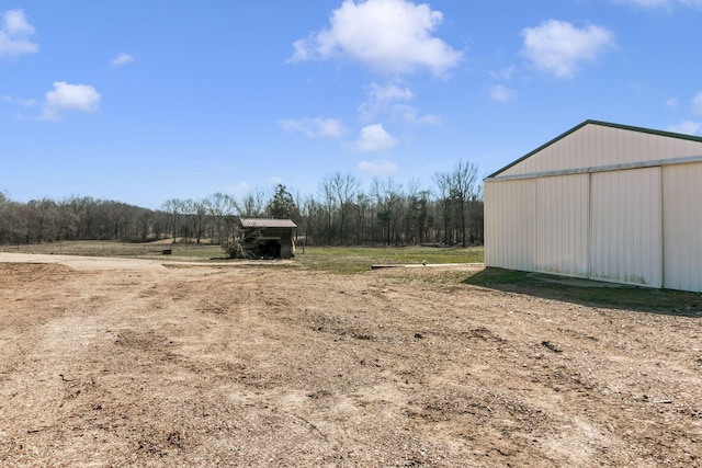 view of yard featuring a detached garage, an outbuilding, and a pole building