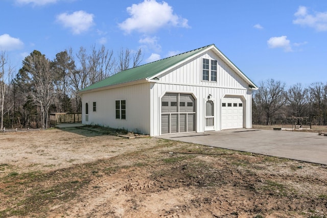 view of side of home with metal roof, a garage, and an outdoor structure