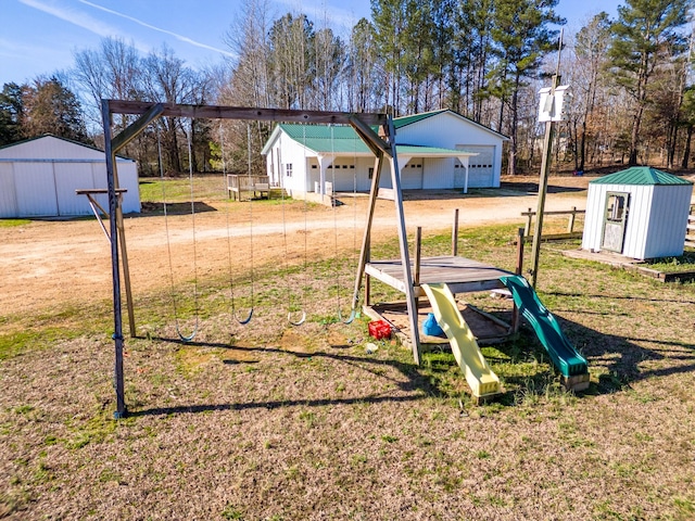 view of yard featuring an outbuilding, a storage shed, dirt driveway, and a playground