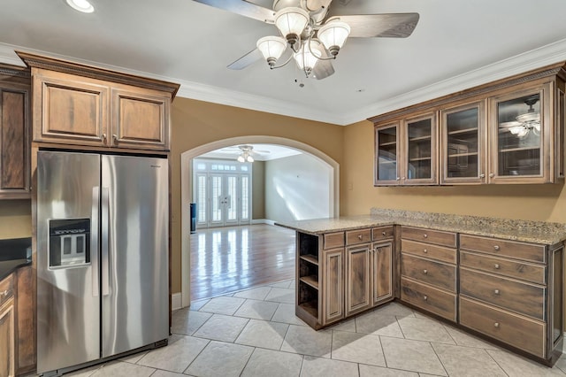 kitchen with open shelves, stainless steel fridge, arched walkways, crown molding, and ceiling fan