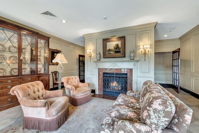 living area with light tile patterned floors, visible vents, a premium fireplace, recessed lighting, and a decorative wall