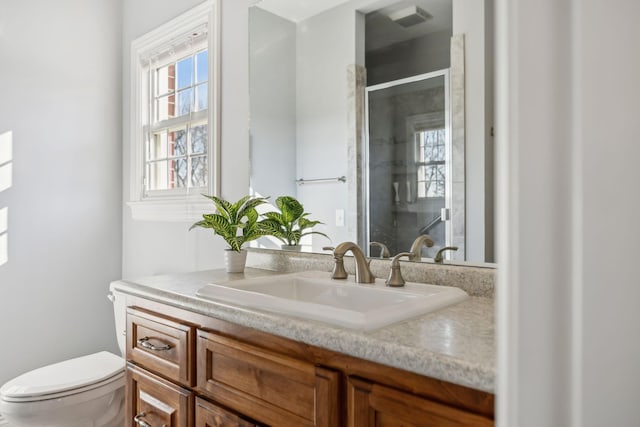 bathroom featuring visible vents, a stall shower, toilet, and vanity