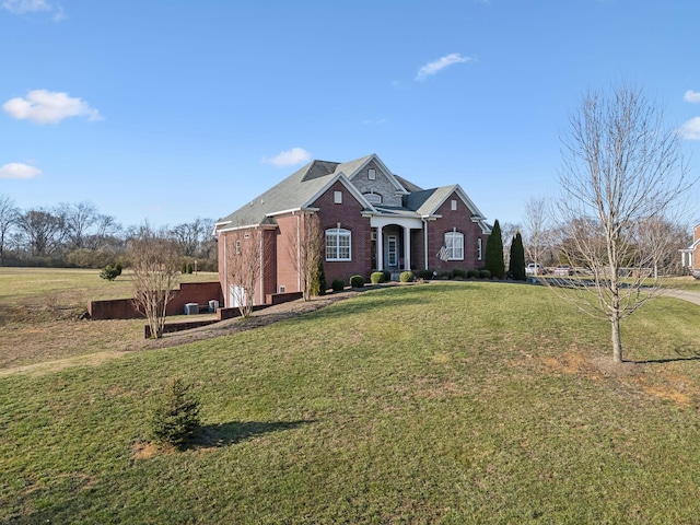 traditional-style house featuring a front lawn and brick siding