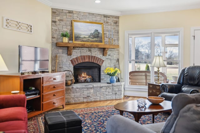 living room with wood finished floors, a fireplace, and ornamental molding