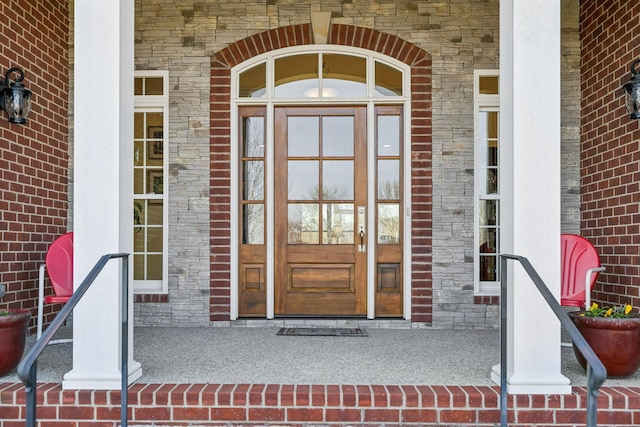 doorway to property with brick siding and stone siding