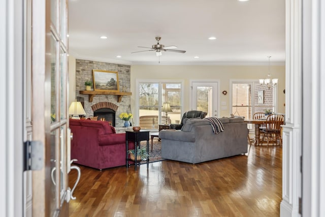 living area featuring recessed lighting, a large fireplace, dark wood finished floors, and crown molding