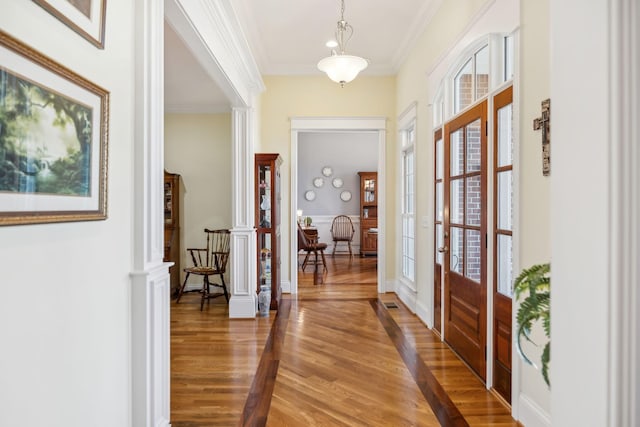 entryway featuring a healthy amount of sunlight, light wood-style flooring, and crown molding