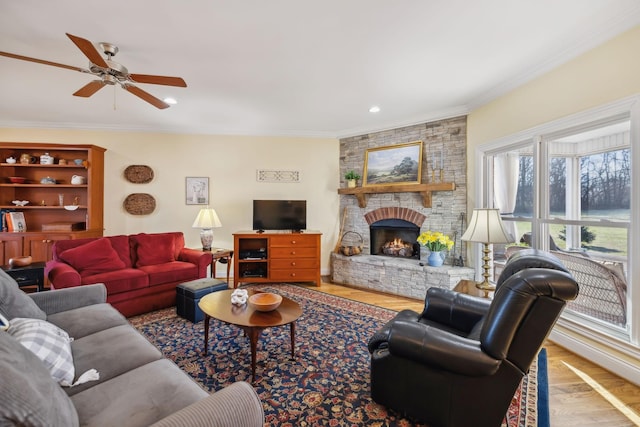 living area with a ceiling fan, crown molding, a brick fireplace, and wood finished floors