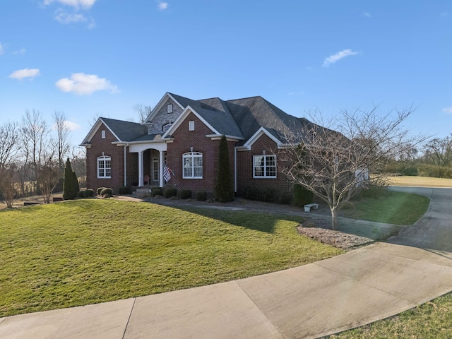 view of front facade with brick siding and a front yard