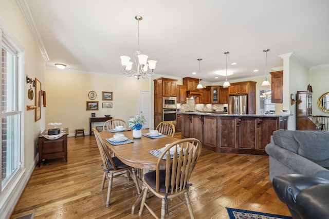 dining area featuring recessed lighting, a chandelier, wood finished floors, and ornamental molding