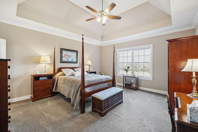 bedroom featuring crown molding, baseboards, a tray ceiling, carpet flooring, and a ceiling fan