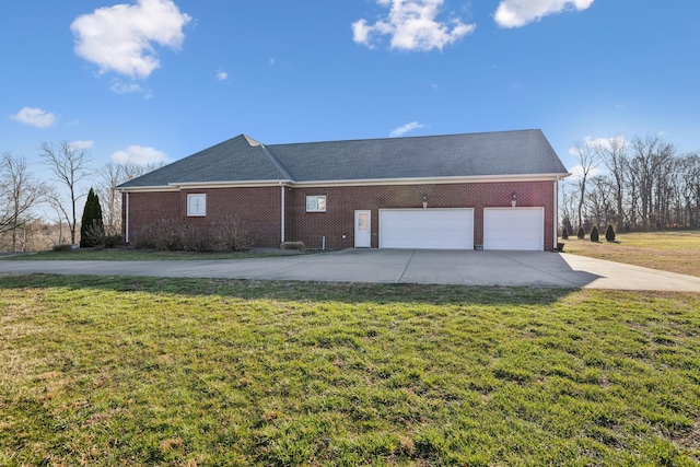 view of side of property with a garage, a yard, concrete driveway, and brick siding