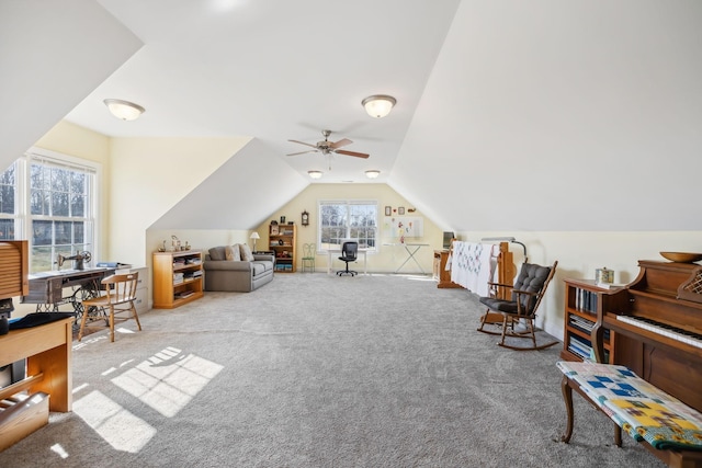 interior space with lofted ceiling, baseboards, carpet floors, and ceiling fan