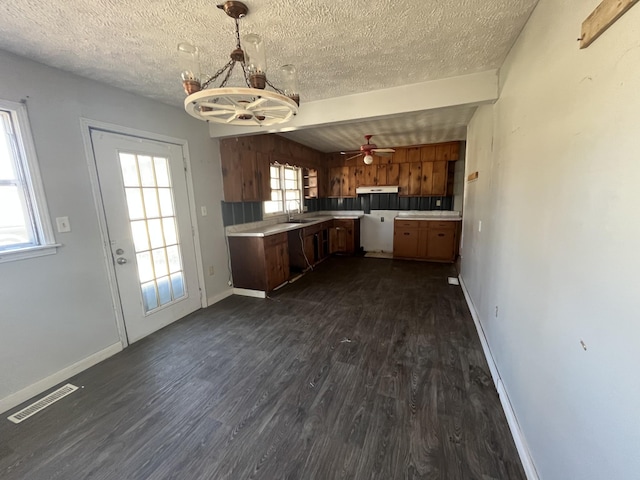 kitchen with dark wood finished floors, light countertops, visible vents, and brown cabinets