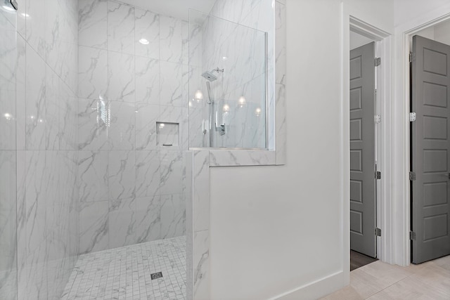 bathroom featuring a marble finish shower and baseboards