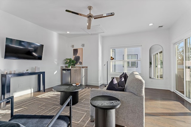 living area with recessed lighting, baseboards, attic access, and wood finished floors