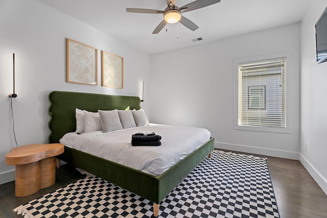 bedroom featuring ceiling fan, wood finished floors, visible vents, and baseboards