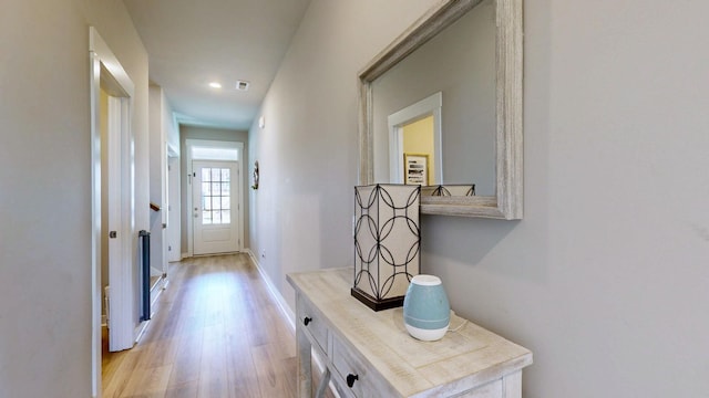 hall featuring baseboards and light wood-style floors