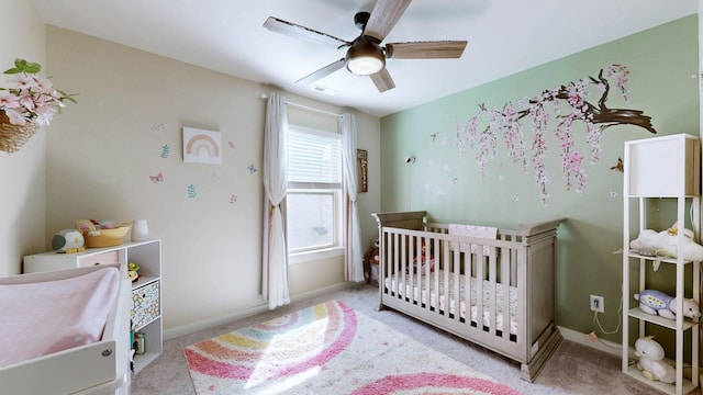 carpeted bedroom with baseboards, visible vents, a ceiling fan, and a nursery area