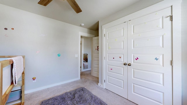 carpeted bedroom featuring baseboards, a closet, and ceiling fan