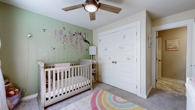 bedroom with a crib, carpet, and baseboards