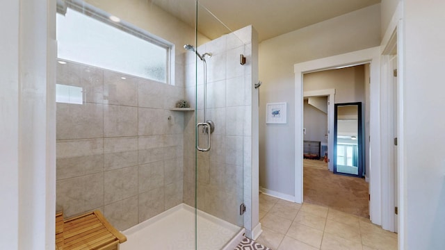 bathroom featuring tile patterned floors, baseboards, and a shower stall