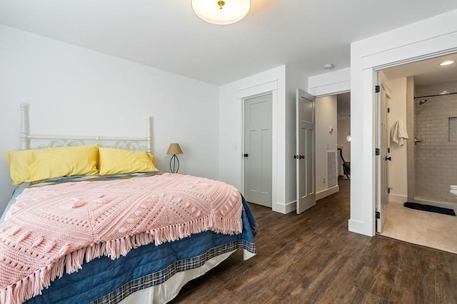 bedroom with connected bathroom and wood finished floors