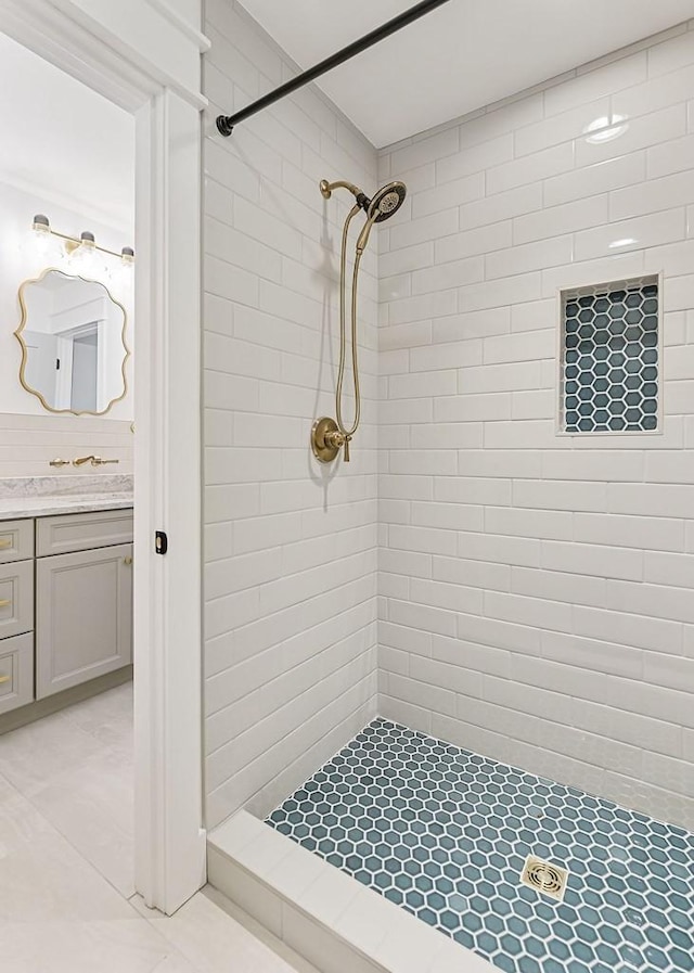 bathroom with tiled shower and vanity