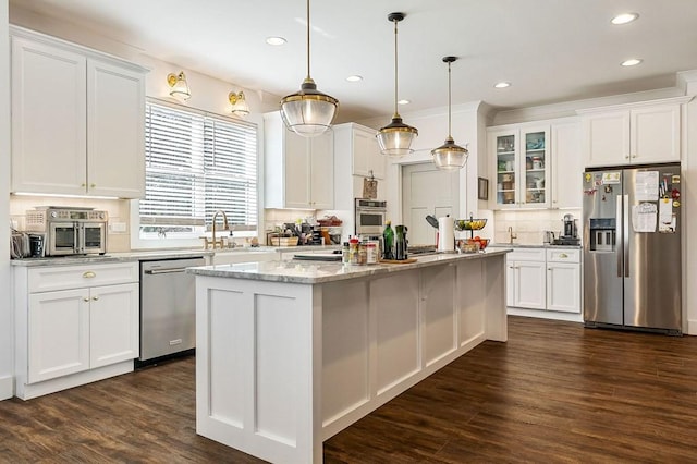 kitchen with a sink, glass insert cabinets, appliances with stainless steel finishes, and white cabinetry