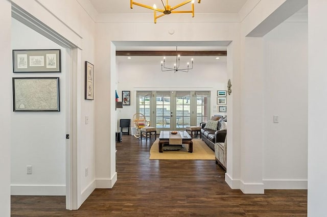 corridor with dark wood-style floors, a notable chandelier, french doors, and baseboards