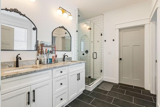 bathroom with double vanity, tile patterned flooring, a shower stall, and a sink