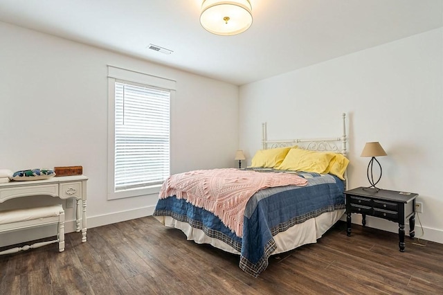 bedroom with visible vents, multiple windows, baseboards, and wood finished floors