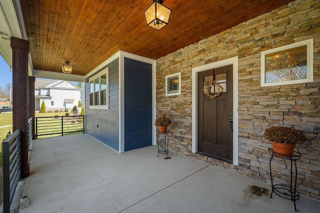 property entrance featuring stone siding and a porch