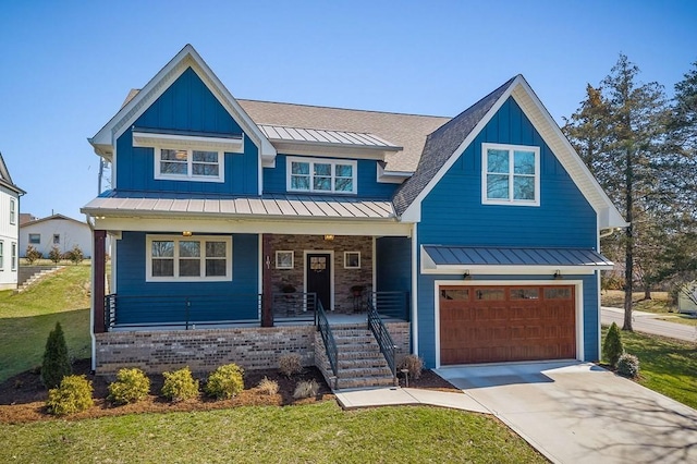 view of front of home with driveway, a standing seam roof, an attached garage, covered porch, and metal roof