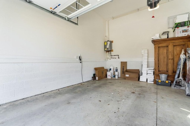 garage featuring a garage door opener and concrete block wall