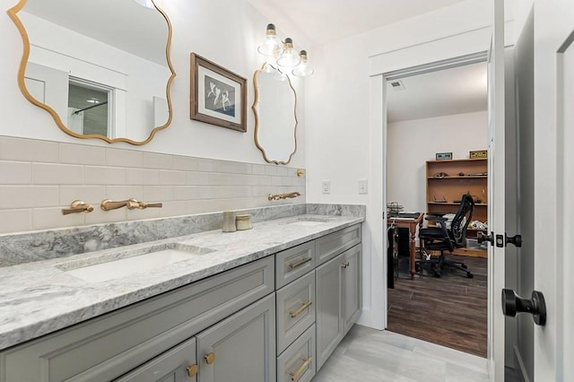 bathroom featuring double vanity, visible vents, backsplash, and a sink