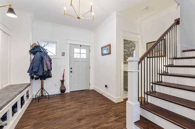 entrance foyer with stairway, wood finished floors, baseboards, crown molding, and a notable chandelier