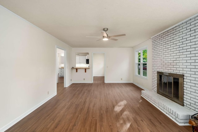 unfurnished living room featuring ceiling fan, baseboards, wood finished floors, and a fireplace