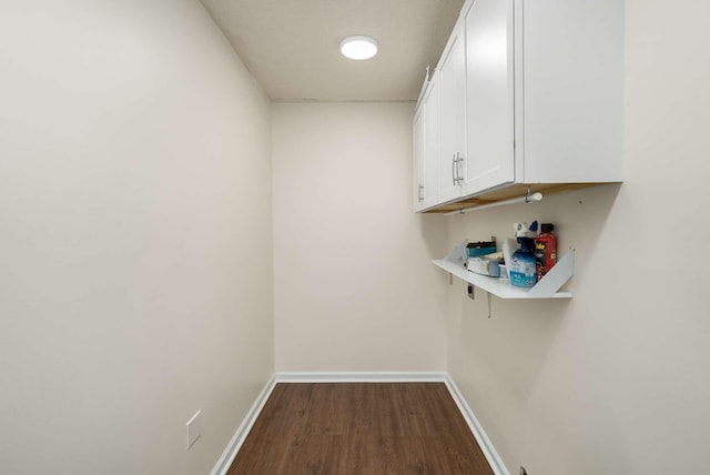 laundry area with dark wood-style floors and baseboards