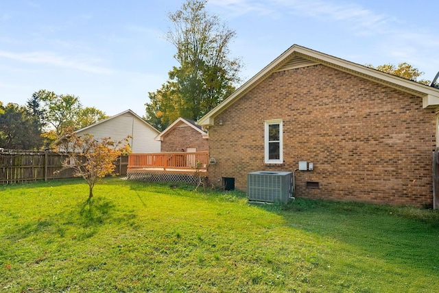 back of house with central AC, fence, a yard, a wooden deck, and brick siding