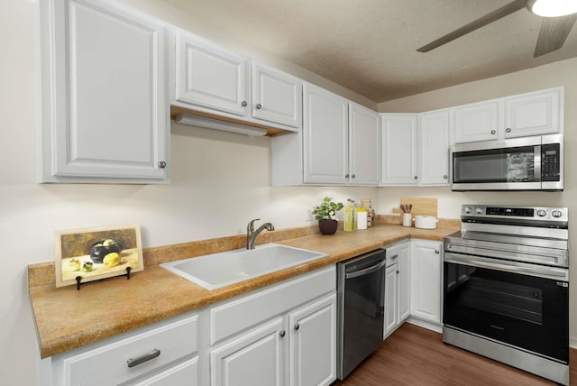 kitchen with a sink, dark wood-style floors, white cabinetry, and stainless steel appliances