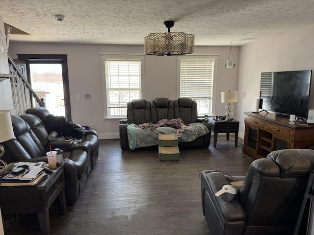 living area featuring dark wood-style floors, a textured ceiling, baseboards, and a wealth of natural light