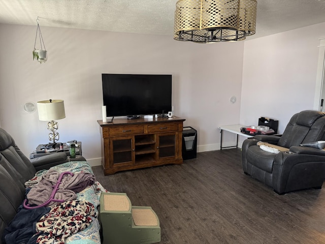 living room with wood finished floors, baseboards, and a textured ceiling