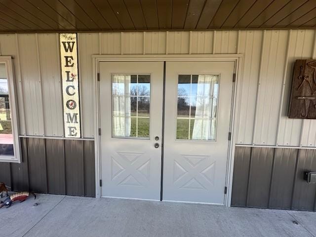 property entrance featuring french doors and board and batten siding