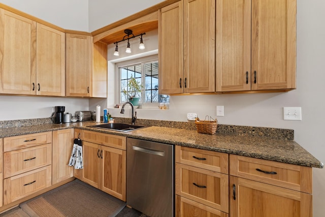 kitchen featuring a sink, dark stone counters, stainless steel dishwasher, and light brown cabinets