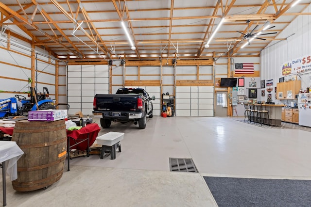 garage featuring metal wall and freestanding refrigerator