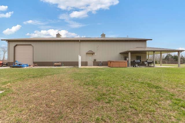 back of house with a patio area, a lawn, and a hot tub